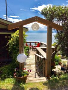 a wooden deck with a view of the ocean at Blitz Beach House Oceanside Suite in Powell River
