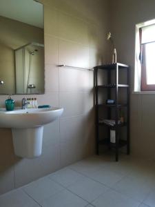 een badkamer met een wastafel en een spiegel bij DaLagoa Charm Villa Pool Beach in Vau