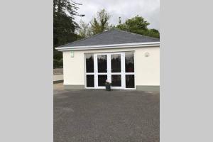 una casa blanca con muchas ventanas en Robin's Nest, en Donegal