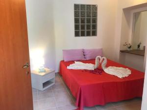a bedroom with two swans on a red bed at Casal Baratz in Santa Maria la Palma