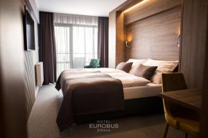 a hotel room with a bed and a window at Hotel Eurobus in Kaluža