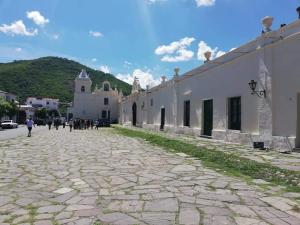 a cobblestone street in front of a white building at Santa Fe Suites Apart in Salta