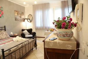 una habitación con una cama y un jarrón de flores sobre una mesa en La casa di Ada, en Sondrio