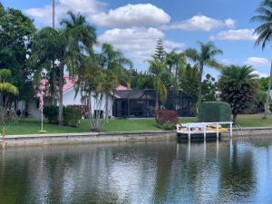 una casa con un barco en medio de un lago en Villa Endless Love en Cape Coral