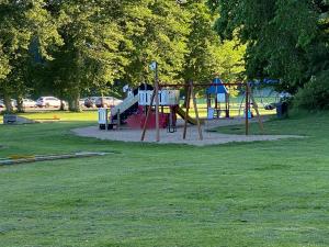 a playground with a slide in a park at Café Mandeltårtan B&B VillaFloraViola in Ronneby