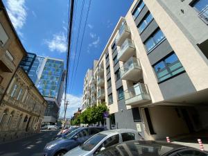 Una fila de autos estacionados en una calle al lado de un edificio en Ultracentral luxury apartment, en Cluj-Napoca