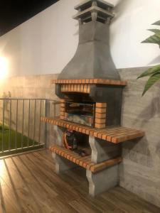Casas Juani- chalet con piscina في كونيل دي لا فرونتيرا: يوجد فرن بيتزا يعمل بالخشب ويقع على الشرفة