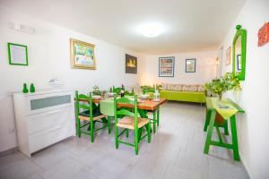 a dining room with a table and green chairs at Casa Bianca Rais Gerbi in Finale
