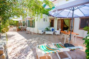 a patio with a table and chairs and an umbrella at Casa Bianca Rais Gerbi in Finale
