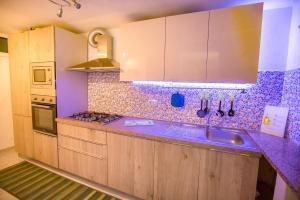 a kitchen with wooden cabinets and a purple counter top at Casa Bianca Rais Gerbi in Finale