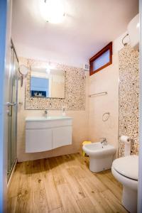 a bathroom with a sink and a toilet and a mirror at Casa Bianca Rais Gerbi in Finale