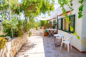 a patio with a table and chairs and trees at Casa Bianca Rais Gerbi in Finale