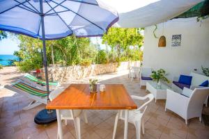 a table and chairs and an umbrella on a patio at Casa Bianca Rais Gerbi in Finale