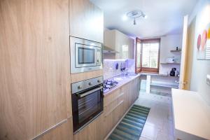 a kitchen with a stove and a microwave at Casa Bianca Rais Gerbi in Finale