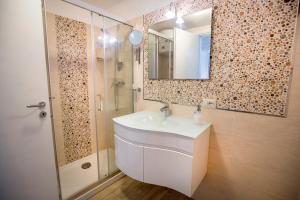 a bathroom with a sink and a mirror and a shower at Casa Bianca Rais Gerbi in Finale