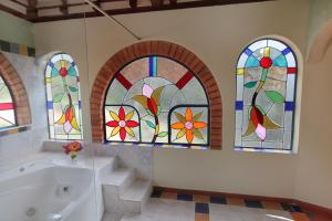 a bathroom with a tub and stained glass windows at Suites Arcoiris in Villa de Leyva +81 photos