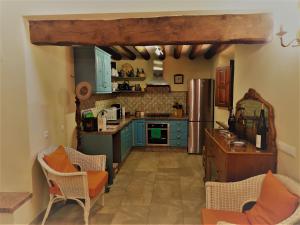 a kitchen with blue cabinets and orange chairs at Cortijo Don Enrique in Restábal