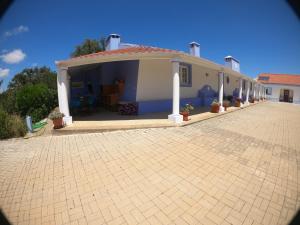 uma casa com uma entrada de tijolos em frente em Country House Porto Covo, Monte da Casa Velha em Santiago do Cacém