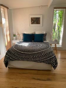 a bedroom with a large bed with blue pillows at Garden Cottage St Kilda in Melbourne