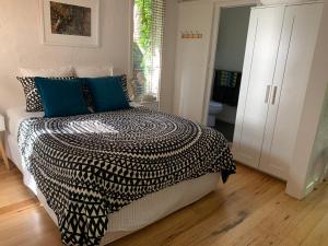 a bedroom with a bed with a black and white comforter at Garden Cottage St Kilda in Melbourne