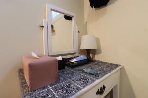 - une commode avec un miroir et une valise dans l'établissement Just4u Guesthouse, à Séoul