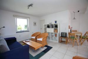a living room with a blue couch and a table at Fewo Kaiser Am Lindenpark - Free Wifi in Kühlungsborn