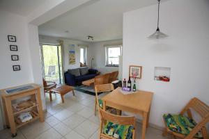 a kitchen and living room with a table and chairs at Fewo Kaiser Am Lindenpark - Free Wifi in Kühlungsborn