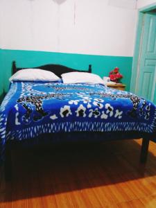 a bed with a blue comforter with animals on it at Nápoles Emperador II in Ambato