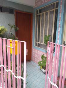 uma cerca rosa em frente a uma casa em Casa Rodriguez " Expo Center Norte " em São Paulo