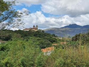 een huis bovenop een heuvel met bomen bij Hotel Pousada do Arcanjo in Ouro Preto