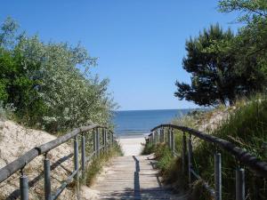 a wooden path leading to the beach with the ocean at Fewo Kaiser Am Lindenpark - Free Wifi in Kühlungsborn