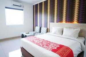 a bedroom with a large bed and a window at Mel's Inn Manado in Manado