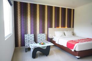 a bedroom with a bed and a table in a room at Mel's Inn Manado in Manado
