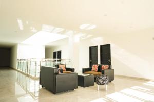 a lobby with couches and chairs in a building at Mel's Inn Manado in Manado