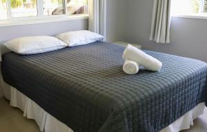ラロトンガ島にあるInave Holidaysのベッド1台(上に枕2つ付)
