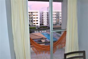 a balcony with a hammock and a view of a building at Aruana beach flat - seu apê na praia de Aruana, Aracaju! in Aracaju