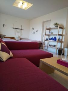 Sala de estar con 2 camas de color púrpura y mesa en KEI, en Lago Toya