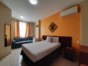 Hotel Air Suites في غواياكيل: غرفه فندقيه بسرير واريكه