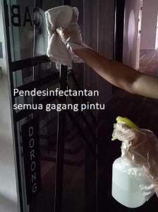 a person is putting something in the door of a refrigerator at Cabin Hotel in Jakarta