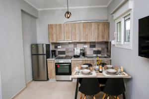 a kitchen with wooden cabinets and a table with chairs at Stella boutigue rooms in Nea Peramos