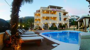 a hotel with lounge chairs next to a swimming pool at Villa Principessa Podstrana in Podstrana