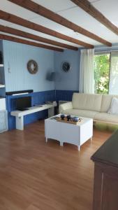 een woonkamer met een witte bank en een salontafel bij Hineni in Oostvoorne