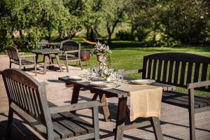 a wooden table and chairs on a wooden deck at Karlamuiza Country Hotel in Kārļi