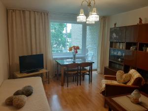 uma sala de estar com uma mesa e uma sala de jantar em Amber apartamentai em Druskininkai