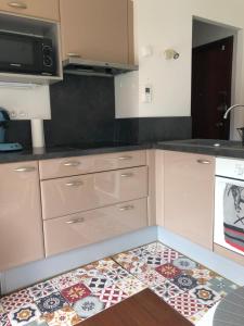 eine Küche mit Fliesenboden in einer Küche in der Unterkunft Appartement cosy, en rez de chaussée, en plein centre de CAmbo les Bains in Cambo-les-Bains + 4 Fotos