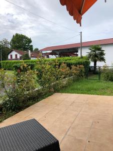 eine Terrasse mit einer Bank im Hof in der Unterkunft Appartement cosy, en rez de chaussée, en plein centre de CAmbo les Bains in Cambo-les-Bains