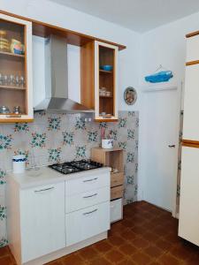 una cucina con mobili bianchi e un forno a piano cottura di Casa Lividonia a Porto Santo Stefano