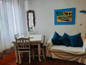un soggiorno con un tavolo e un divano di Casa Lividonia a Porto Santo Stefano Altre 13 foto