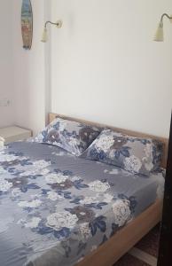 Una cama con un edredón azul y blanco. en Apartment with two rooms near the beach en Asprovalta