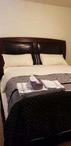 a bed with a black headboard and a book on it at Jule Sleep in Denver